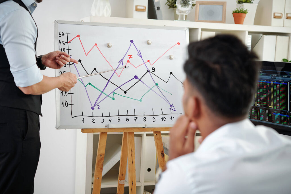 Man presenteert grafiek op whiteboard aan collega