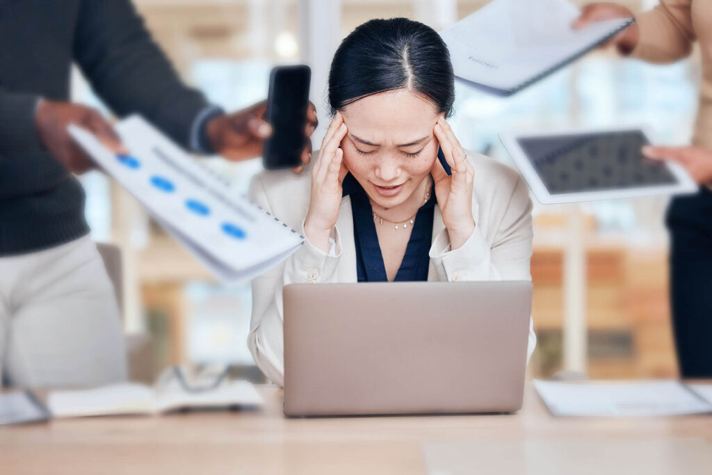 Gestreste vrouw met laptop en opdringerige collega's